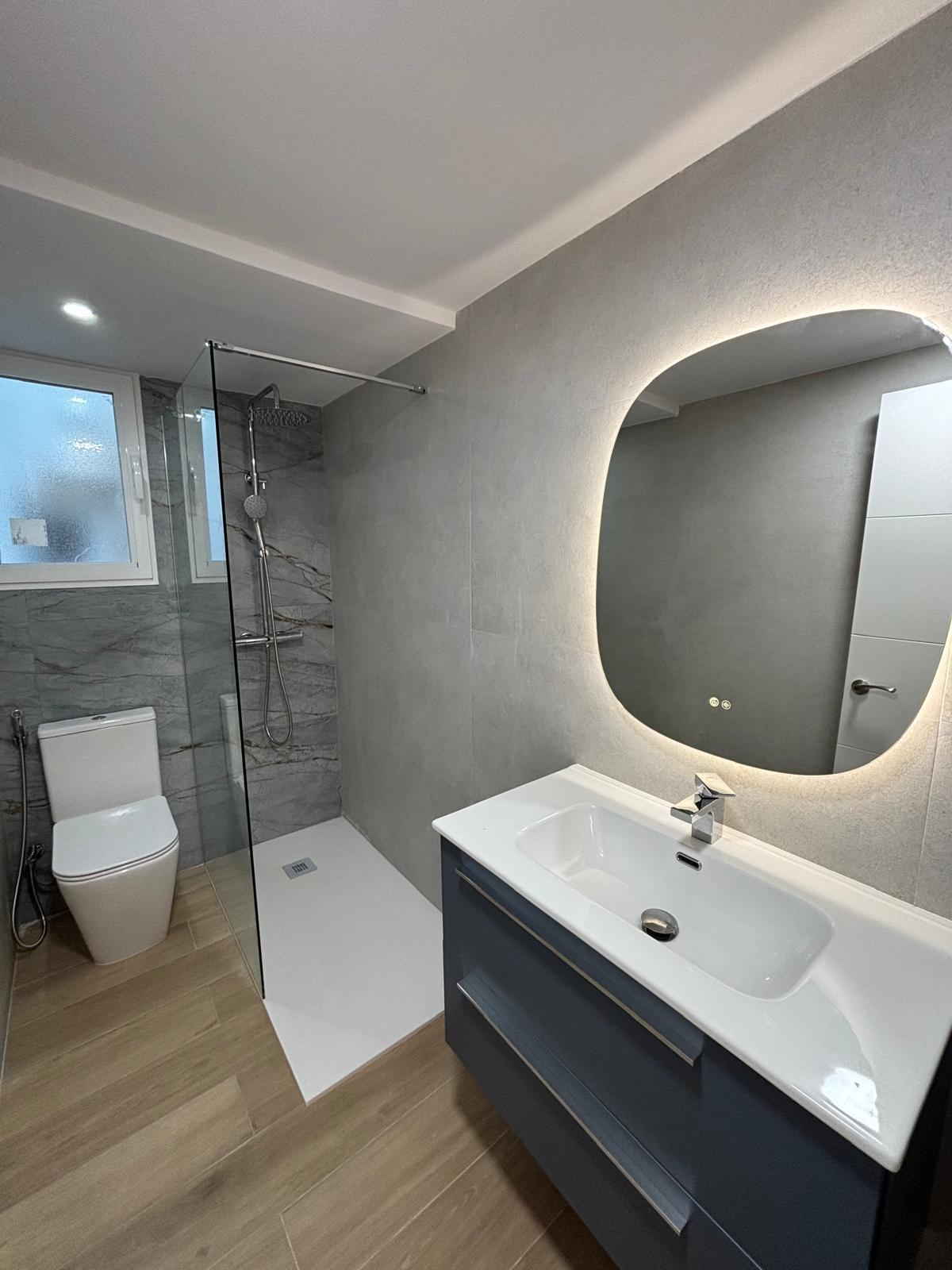Reforma de baño moderno con ducha y lavabo