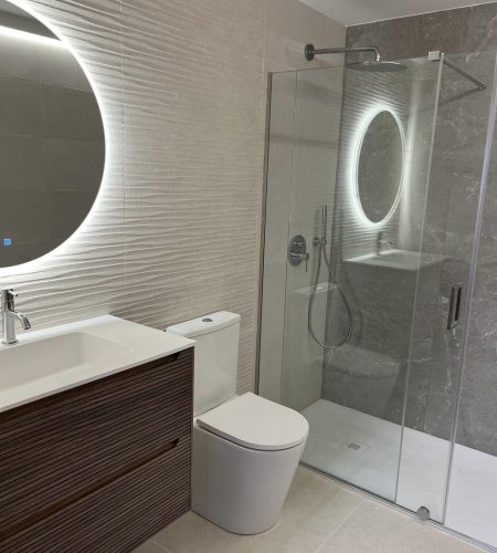 Baño reformado con ducha y espejo iluminado en Valencia